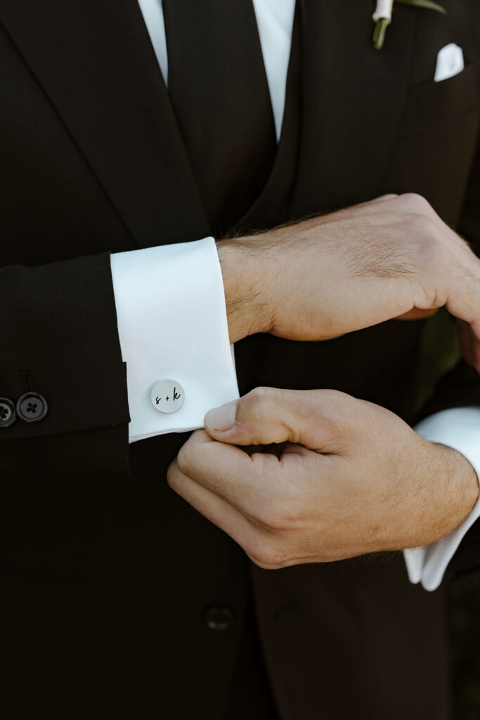 Close up of groom's cuff link with wedding couple's initials at Willow Heights mansion