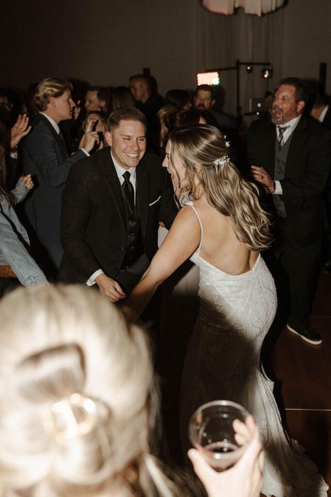 Wedding couple dancing together and with guests while smiling during reception at the PlumpJack Inn