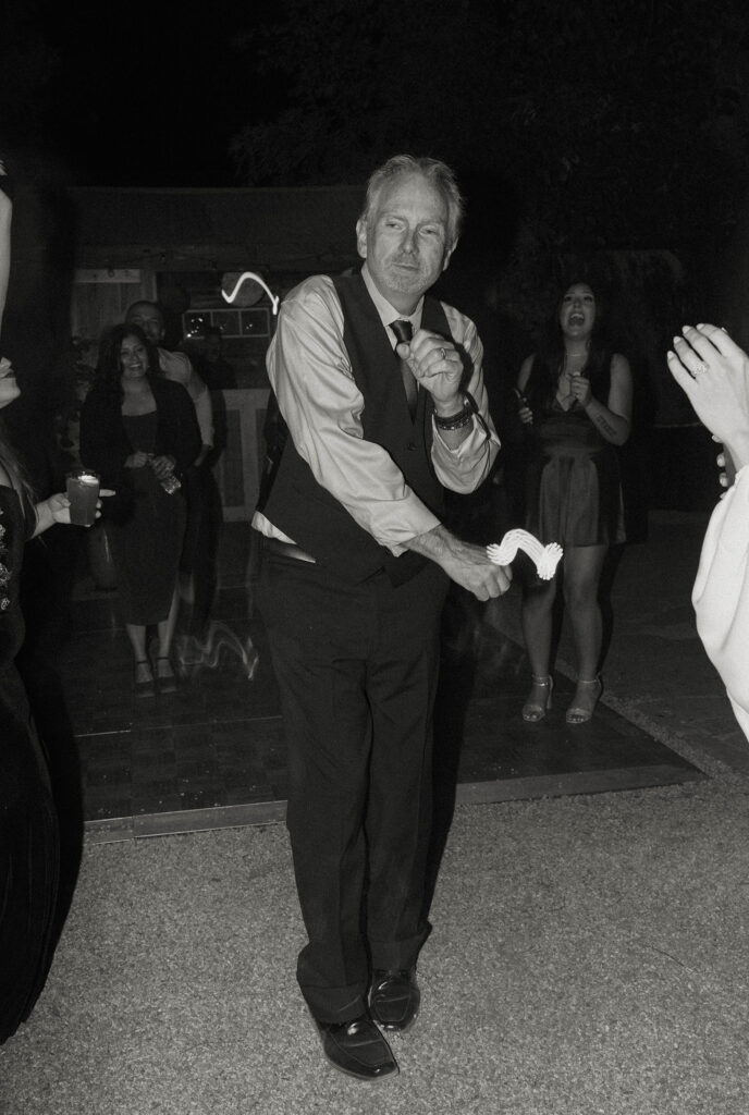 Wedding guest dancing while other guests laugh during reception at Sierra Water Gardens