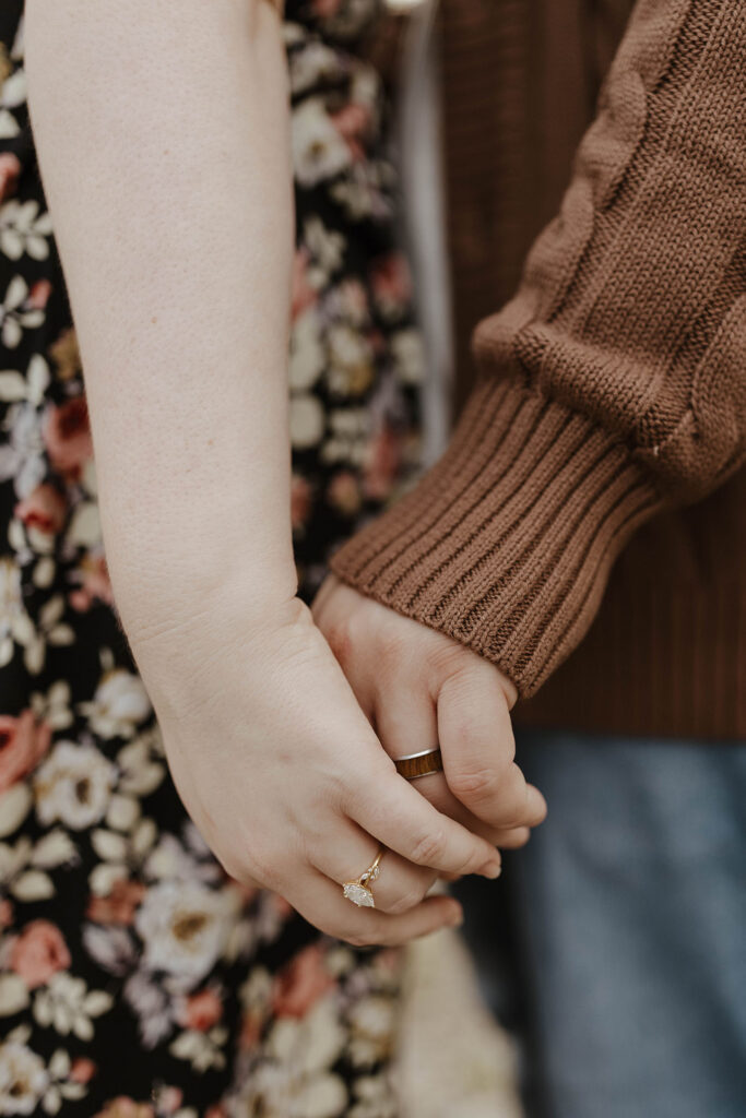 Close up of engagement couple holding hands while wearing engagement rings at Graeagle