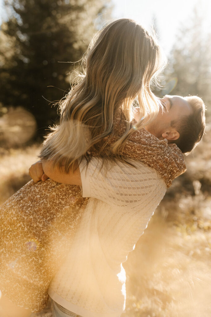 Man lifting fiancé up while surrounded by golden field in Lake Tahoe
