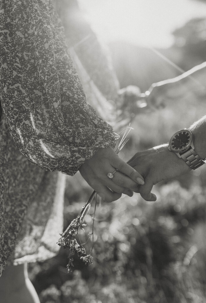 Close up of engagement couple's hands while woman wears engagement ring and holds florals in Lake Tahoe