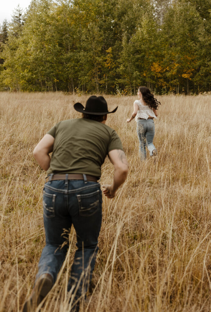 man chasing woman in a meadow in south lake tahoe for their engagement photos