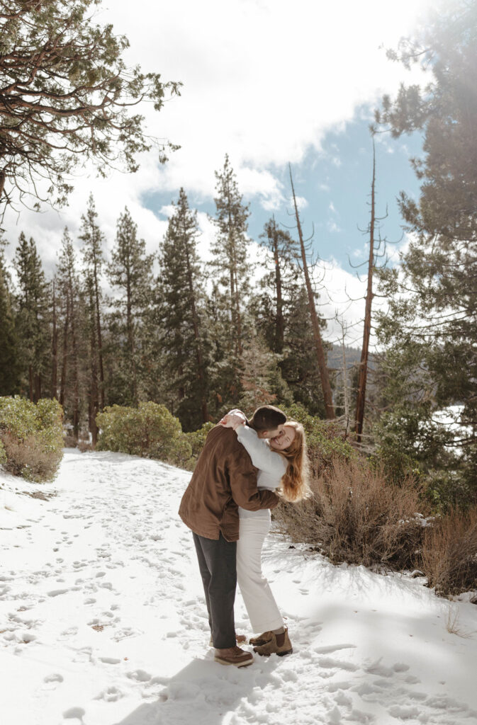 man kissing and dipping woman in the snow in lake tahoe