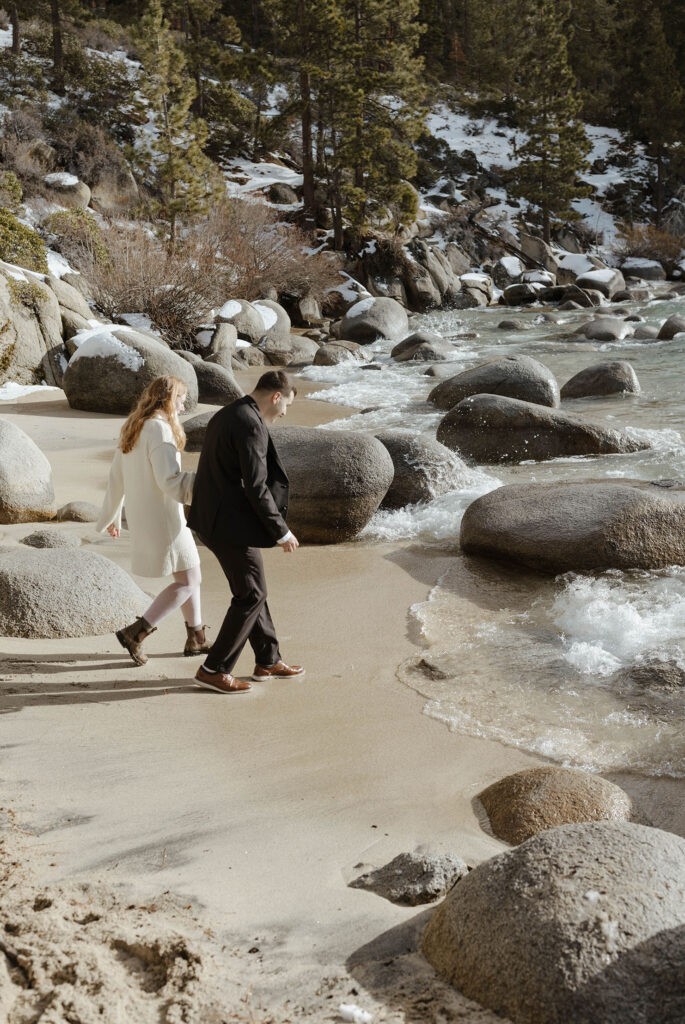 couple running towards the water in lake tahoe