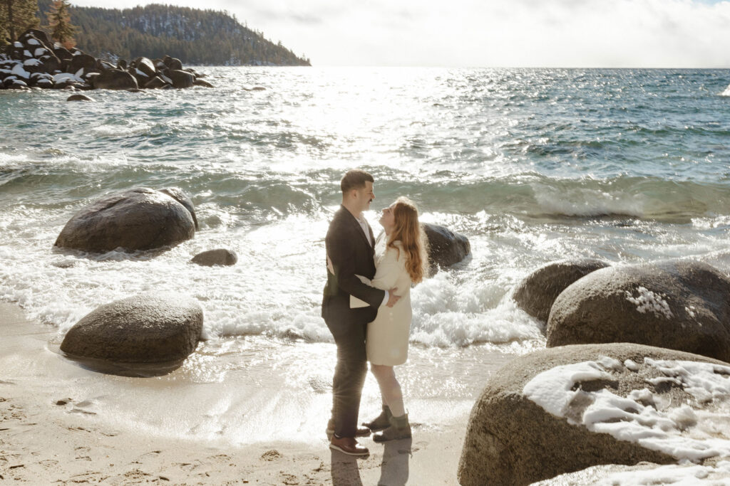 couple hugging on the beach in lake tahoe