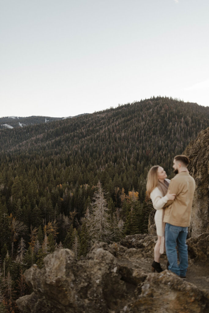 couple hugging out of focus at eagle rock, with lake tahoe in the distance