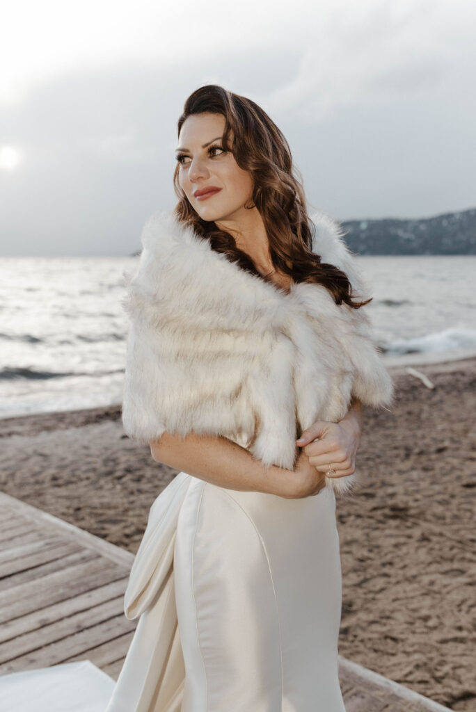 bride looking off wearing a fur coat in the winter in lake tahoe 