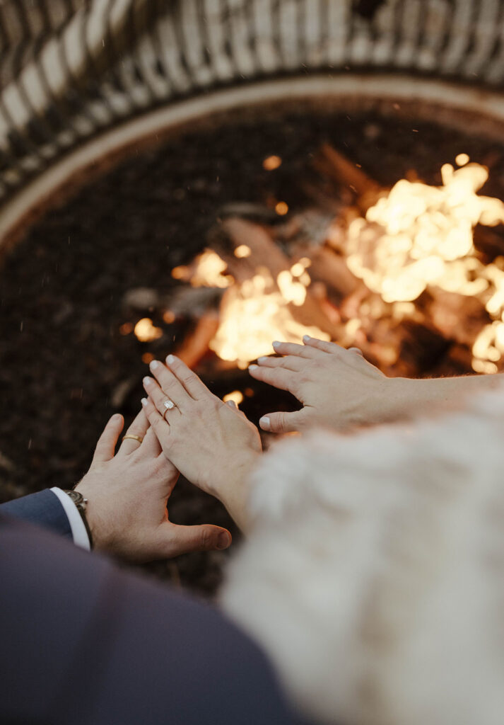newlyweds standing by the fire at the hyatt in lake tahoe and warming their fingers