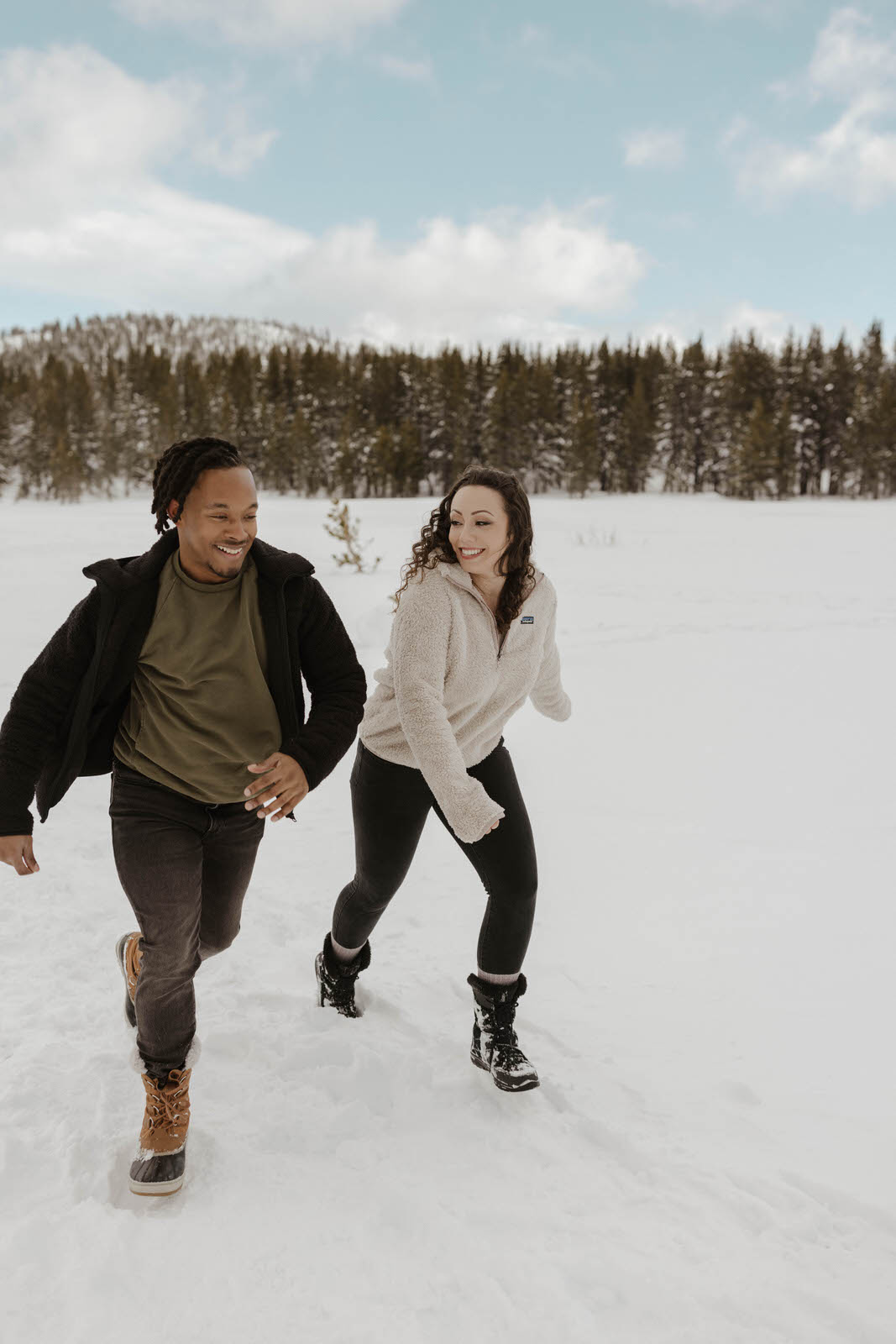 couple running in the snow at mount rose meadows