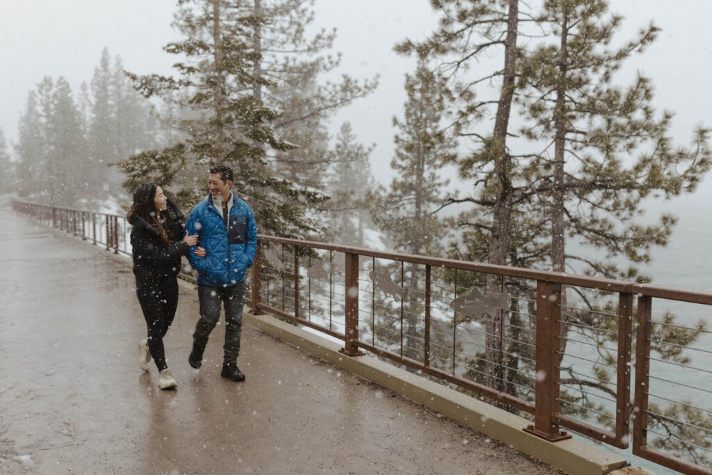 couple walking in the snow on a bridge in lake tahoe