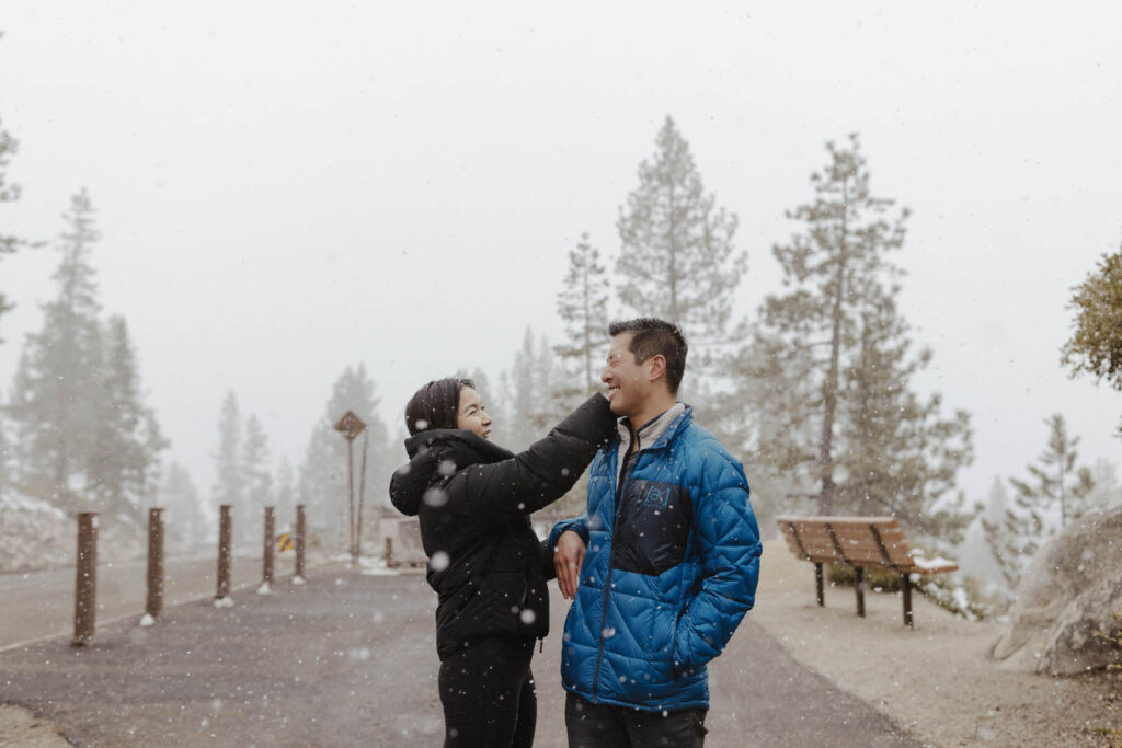 woman wiping snow off man's face and laughing in lake tahoe