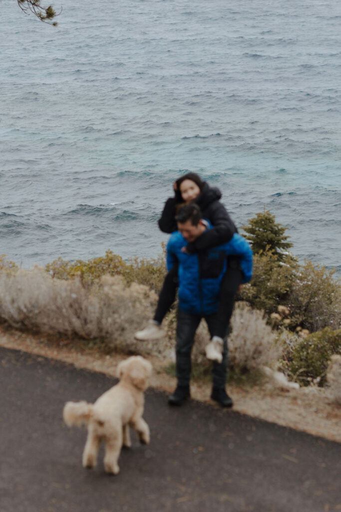 couple giving a piggy back ride with dog in lake tahoe