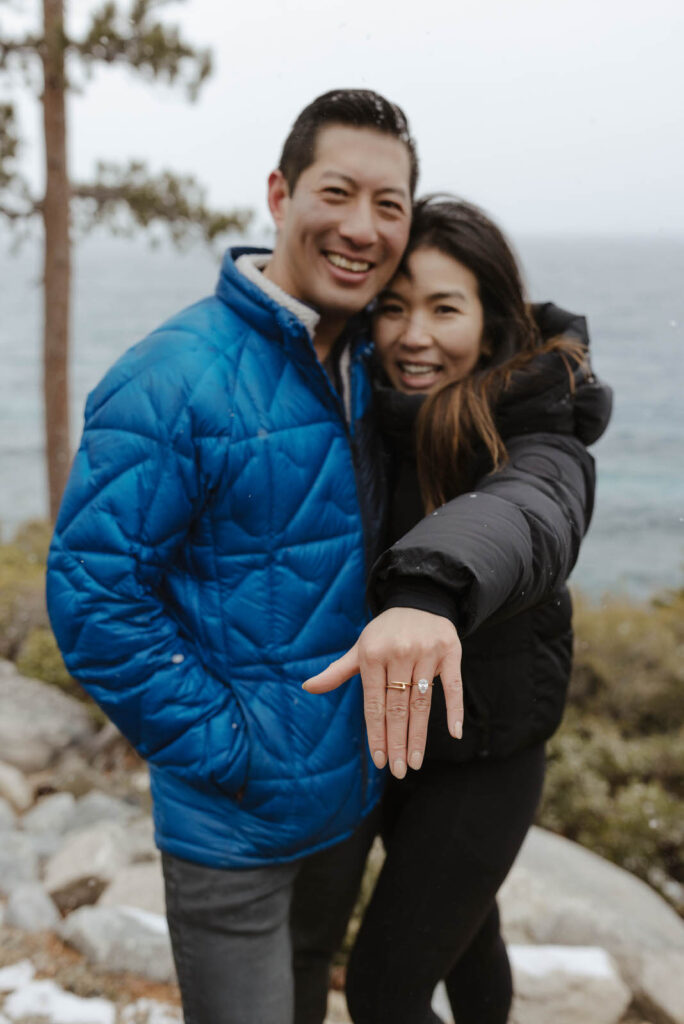 couple showing off ring and smiling in lake tahoe