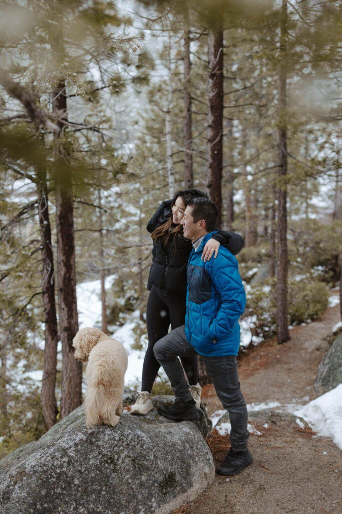 couple hugging in lake tahoe with their dog