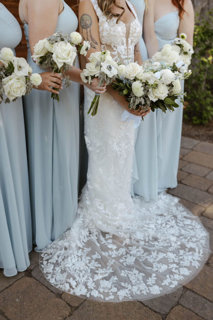 bridesmaids in blue silk dresses holding simple, modern bouquets 