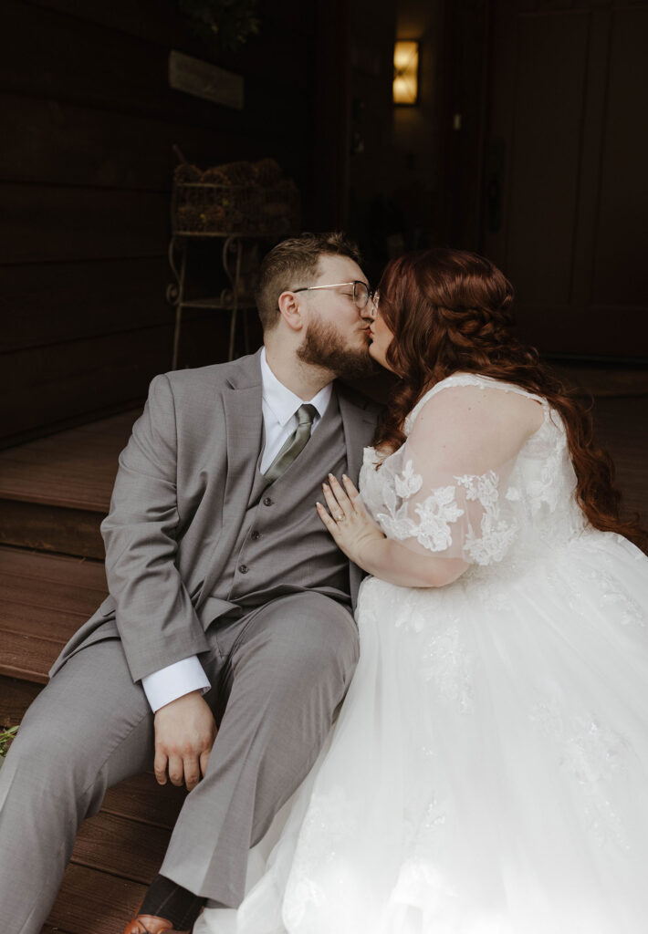 wedding couple sitting on stairs and kissing in graeagle