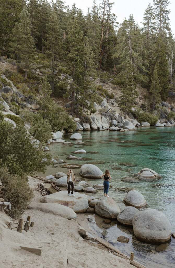 couple standing on rocks in lake tahoe at the beach