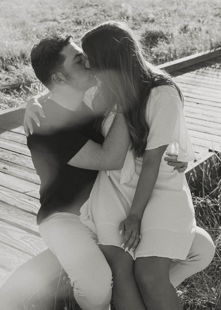 couple kissing on wooden walk way