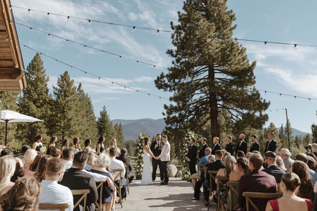 Overview of wedding ceremony at Timbers at Old Greenwood full of guests and with pine trees in background