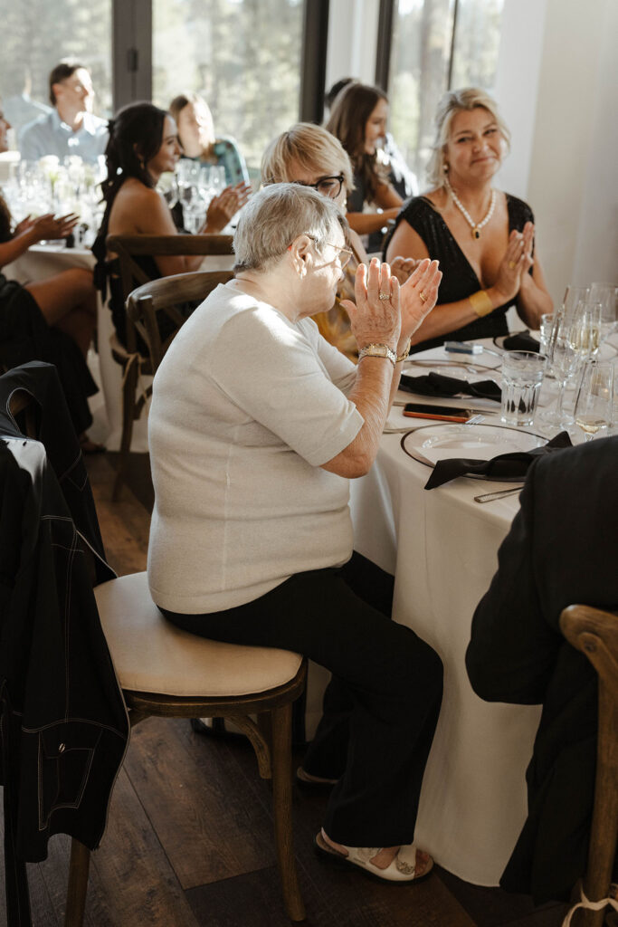 Wedding guests clapping during reception at Timbers at Old Greenwood