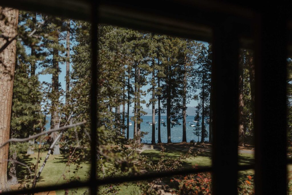 Looking at pine trees and Lake Tahoe through window at Valhalla