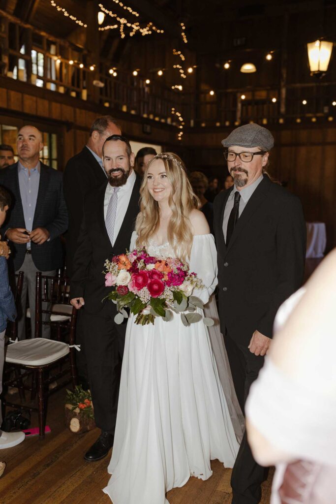 Bride walking down aisle while holding colorful floral bouquet during wedding ceremony at Valhalla in Lake Tahoe