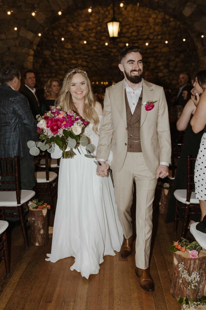 Couple holding hands while walking down aisle together after wedding ceremony at Valhalla in Lake Tahoe