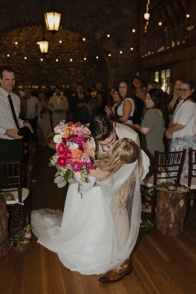 Couple kissing in aisle after wedding ceremony while guests clap at Valhalla in Lake Tahoe