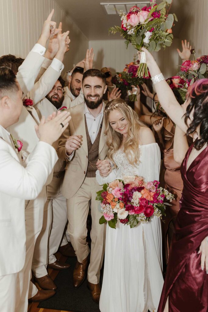 Wedding couple laughing while walking through bridal party as they celebrate at Valhalla in Lake Tahoe