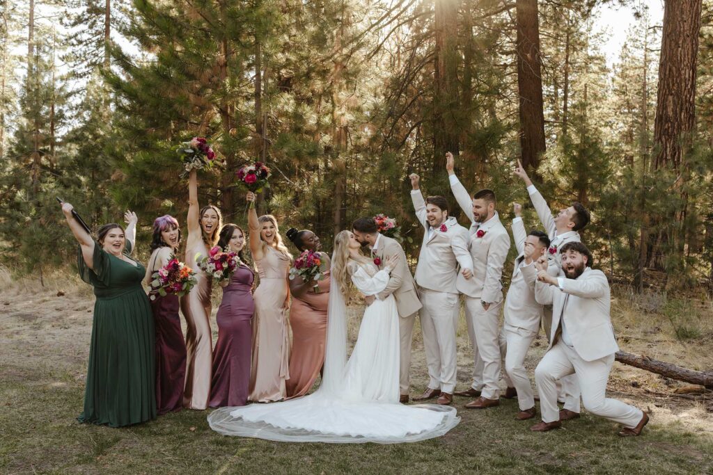 Wedding couple kissing and holding each other while groomsmen and bridesmaids celebrate on either side at Valhalla in Lake Tahoe