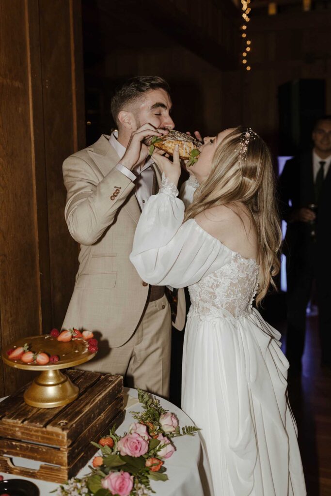 Wedding couple holding and taking bite of wedding cake together at Valhalla in Lake Tahoe