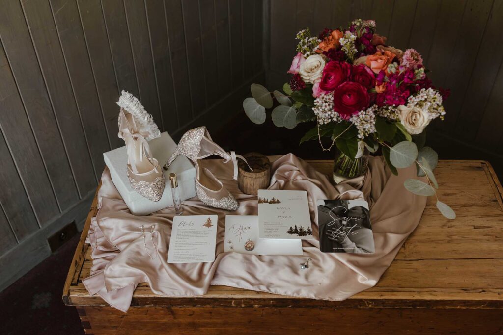 Wedding details in flat lay on silk sheet with colorful floral bouquet at Valhalla in Lake Tahoe