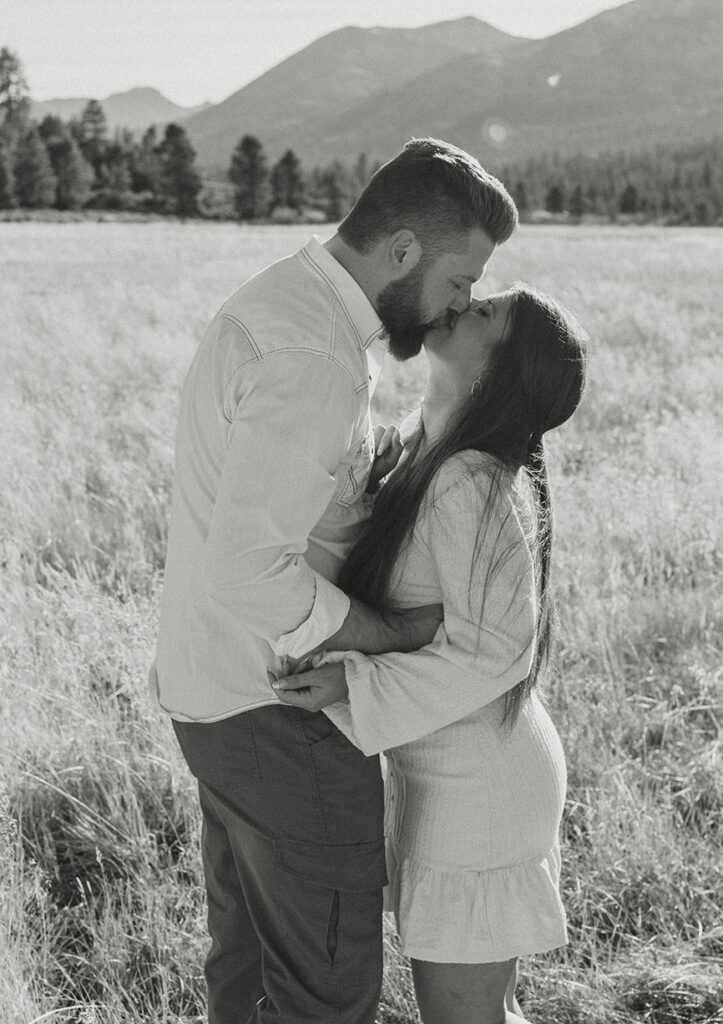 Couple holding each other and kissing during anniversary photoshoot in golden field in Lake Tahoe