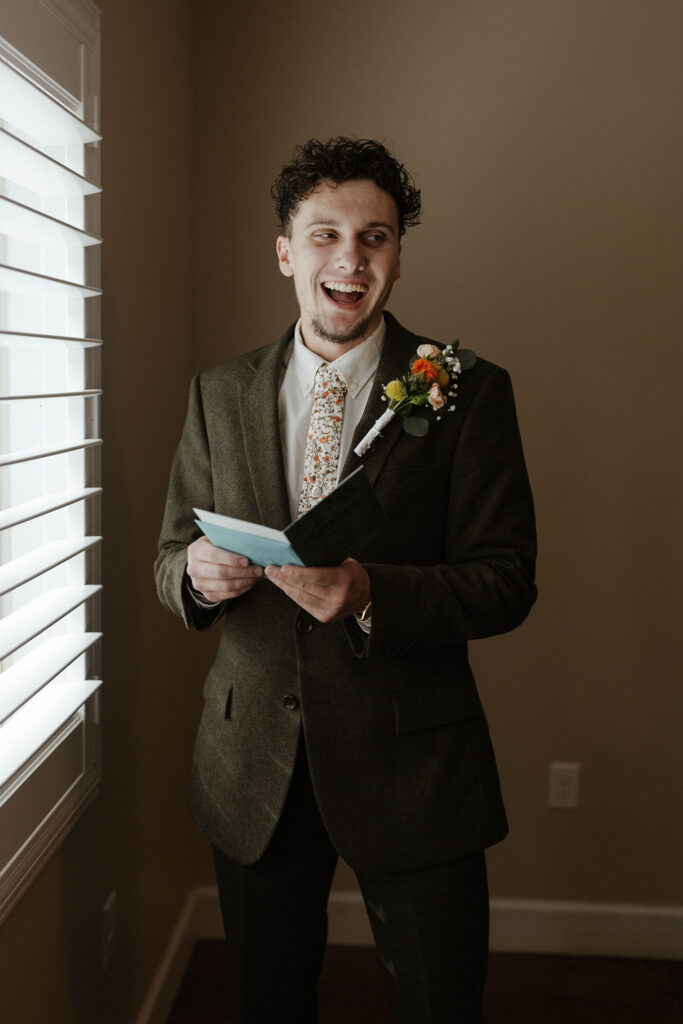 Groom reading card and being excited before elopement in Emerald Bay
