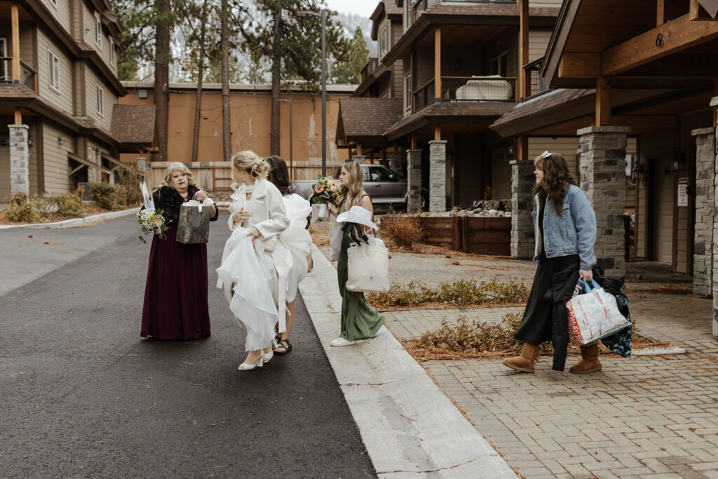 Wedding bride and guests walking across street while carrying elopement details