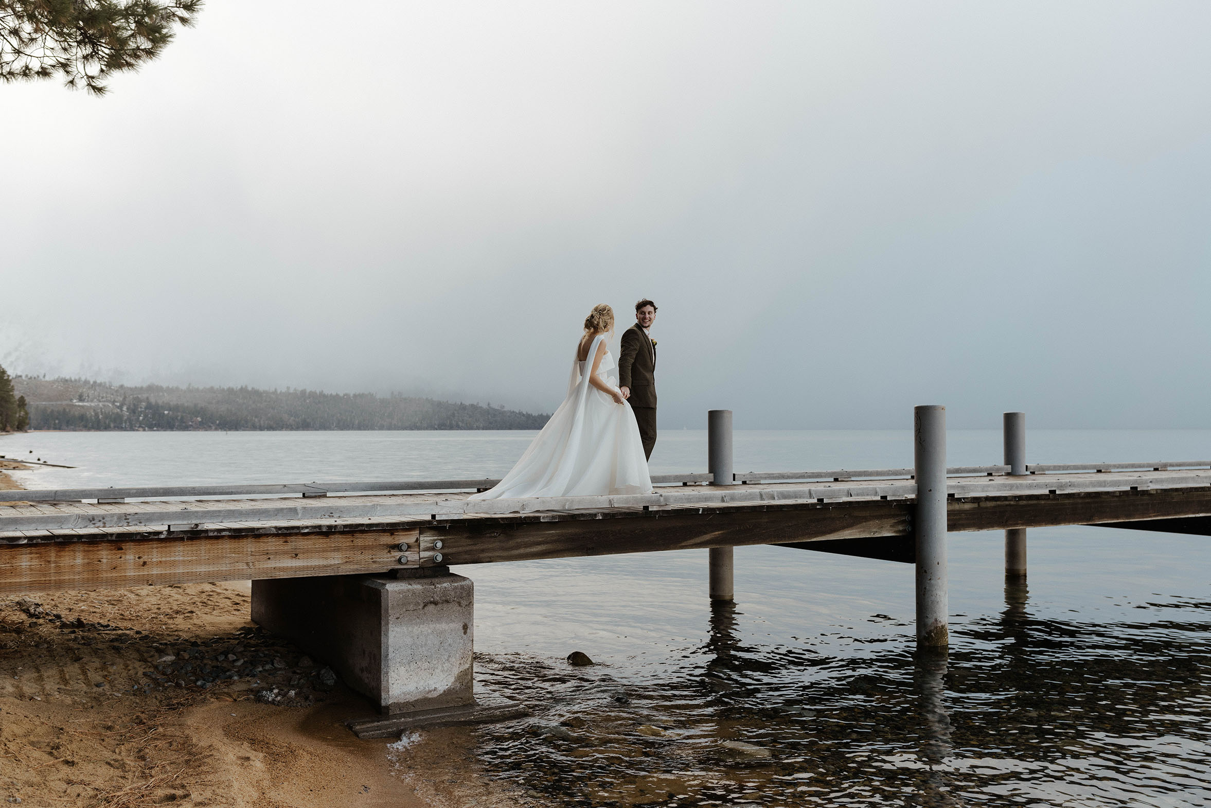 elopement couple walking on a dock in lake tahoe