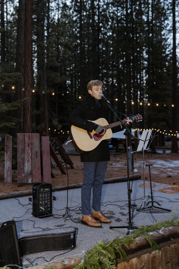 Elopement guest holding guitar and singing during reception in Emerald Bay