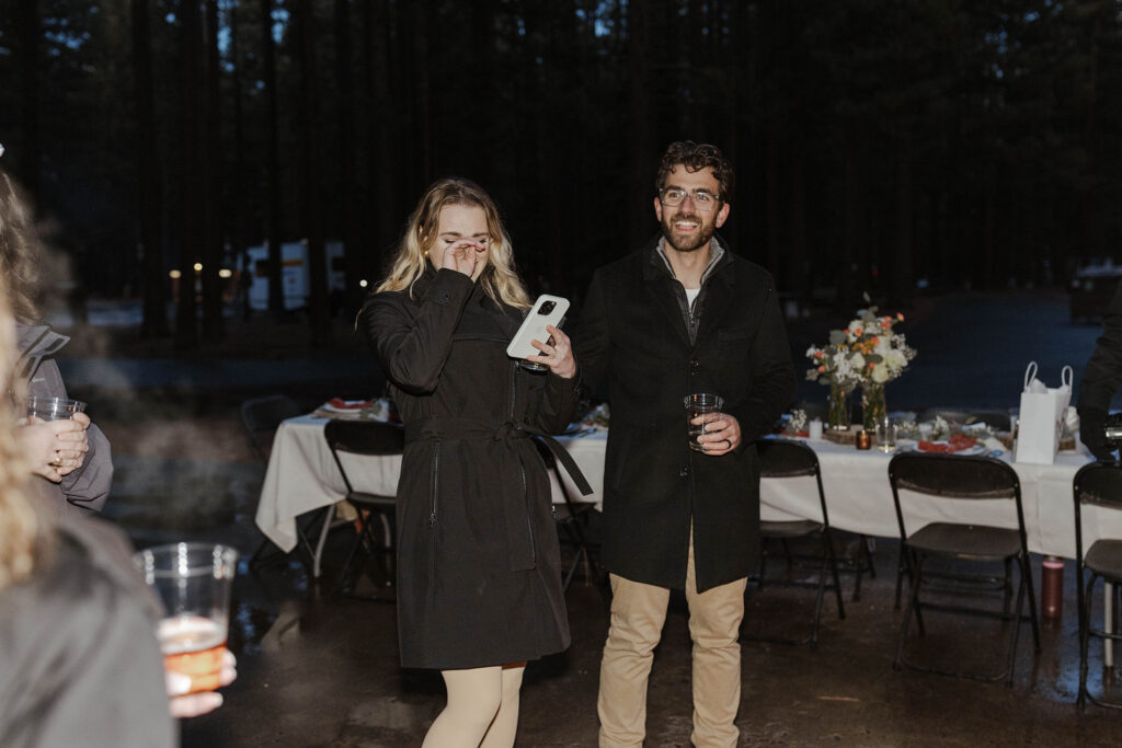 Guests laughing while holding drinks during winter elopement reception in Emerald Bay