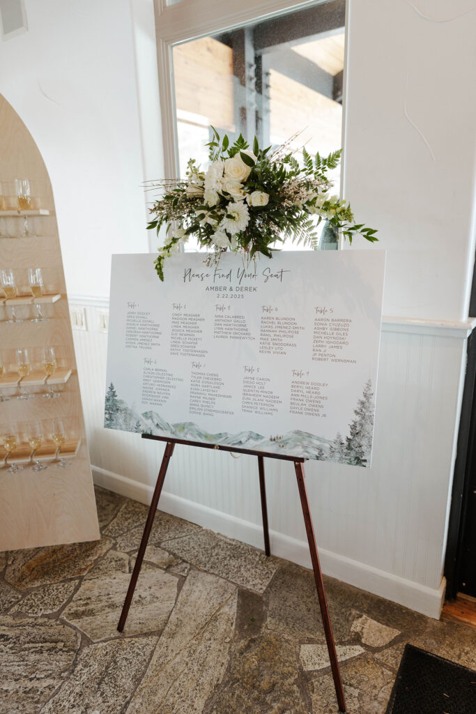 Wedding seating table assignment sign with floral bouquet on top inside at the Tannenbaum