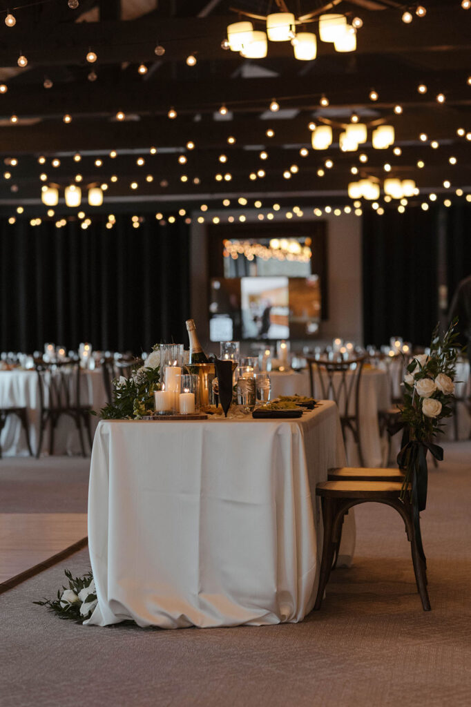 Wedding reception table decorated with candles and white florals at the Tannenbaum
