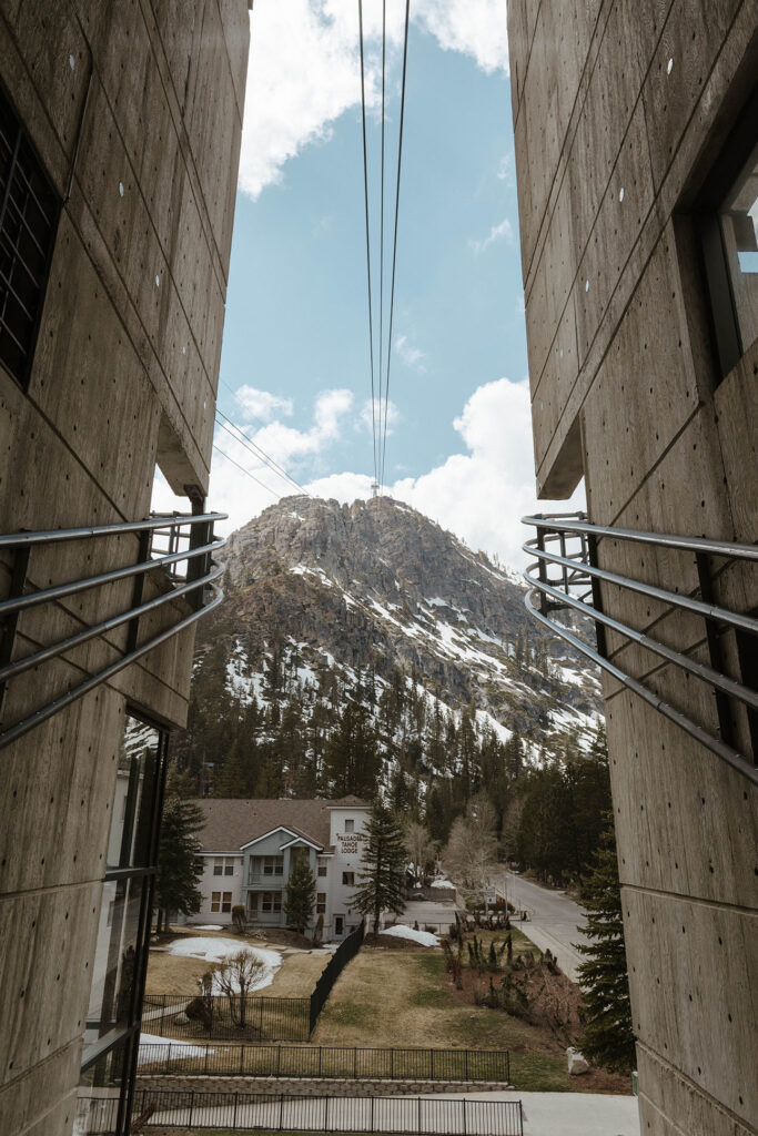Looking through two buildings towards snow covered mountains at Palisades Tahoe