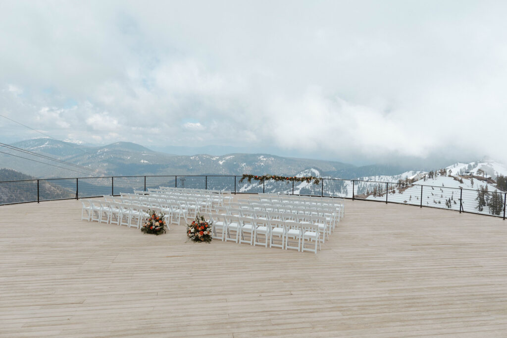 Overview of wedding ceremony before guests arrive at Palisades Tahoe with snowy mountains in background