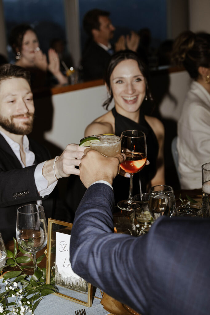 Wedding guests smiling and cheering drinks during reception at Palisades Tahoe