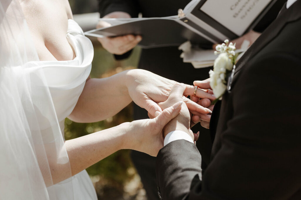 groom putting a ring on the brides finger at a wedding ceremony at tahoe blue estate