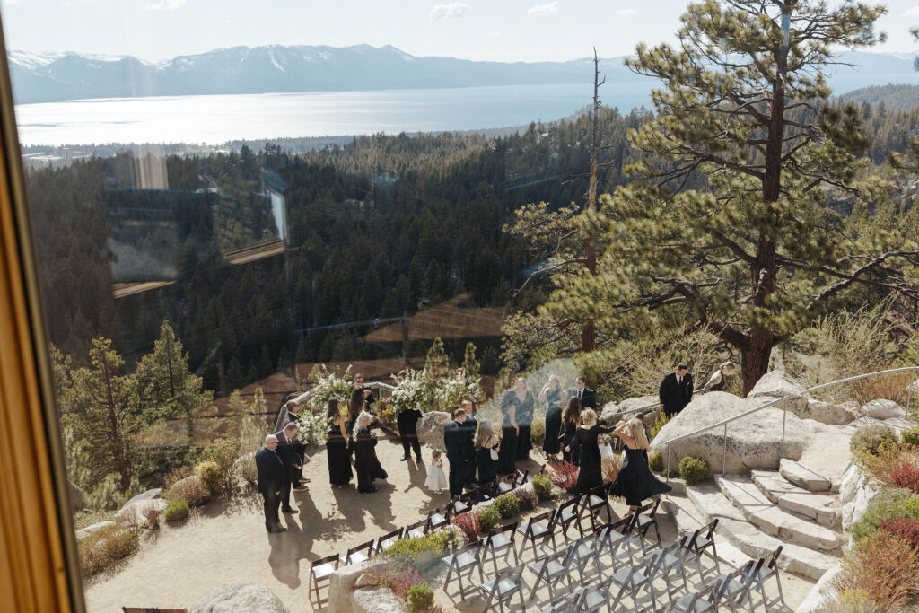 view of wedding guests gathered at tahoe blue estate from an upstairs window looking down on themn