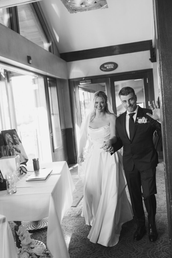 newlyweds entering reception at riva grill seeing their guests for the first time