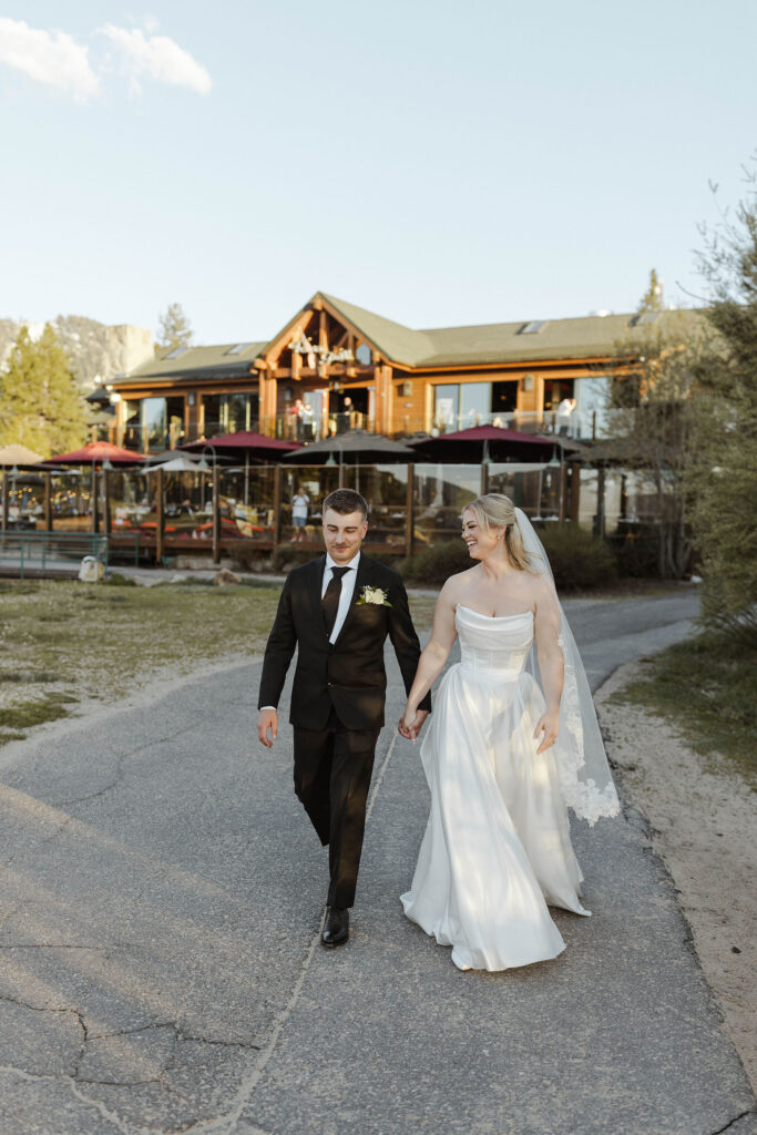 bride and groom walking and smiling hand in hand at riva grill