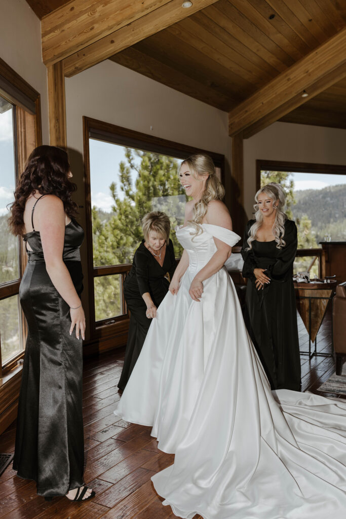 bride getting dressed laughing with her bridesmaids at tahoe blue estate