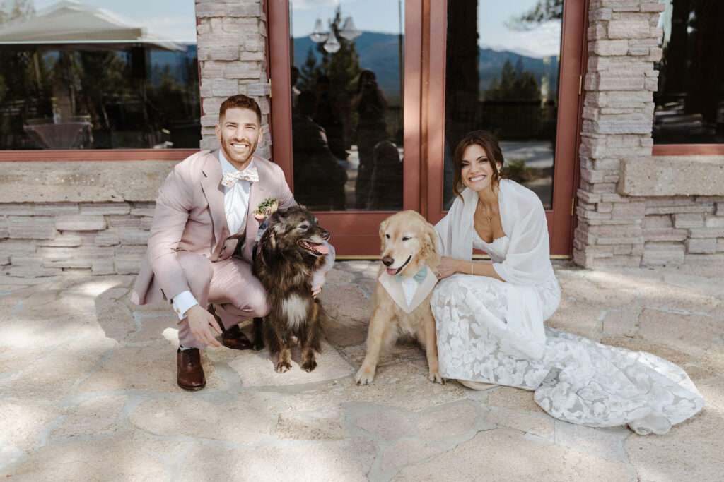 wedding couple squatting and smiling at the camera with their dogs